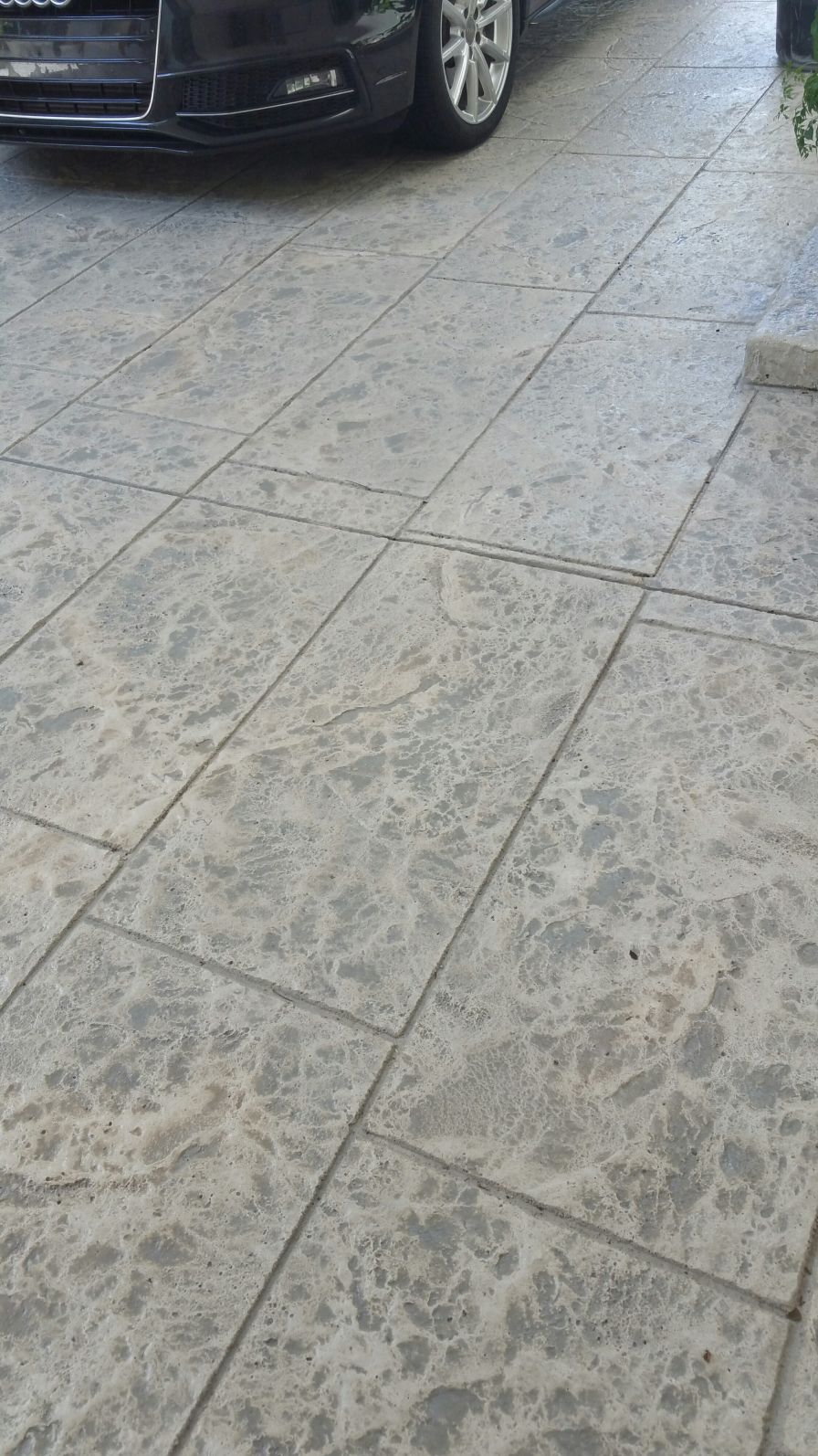 Stamped concrete driveway resurfacing in modern large gray tile pattern