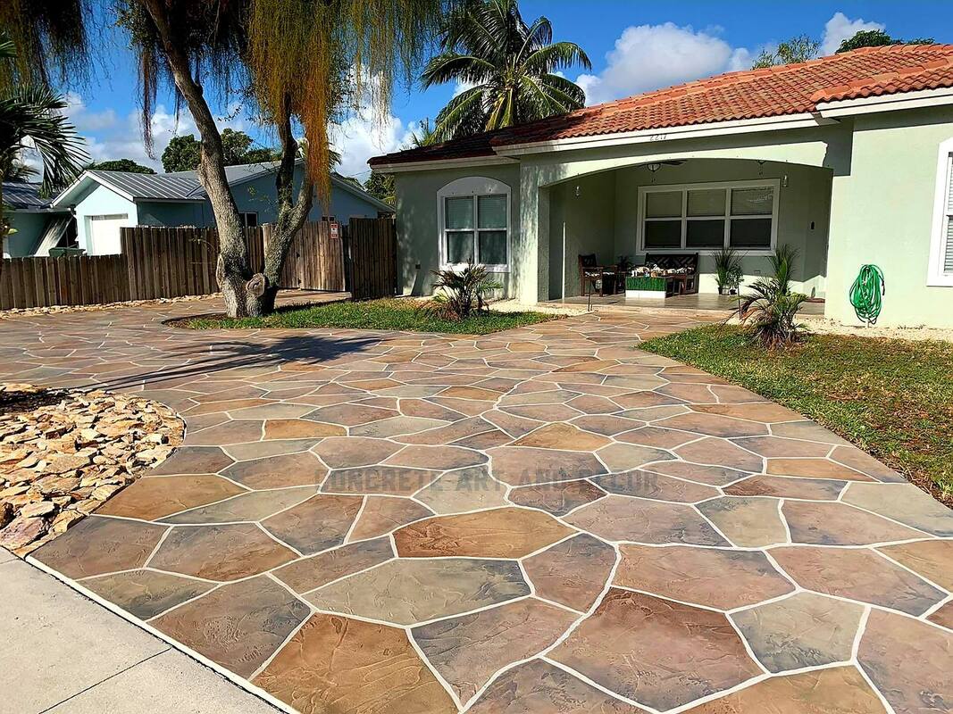 curved stamped concrete driveway in dark gray bordered by light gray stone. 