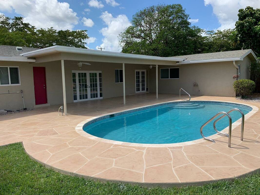 Picture of a house with a beautiful stamped concrete pool deck overlooking the pool
