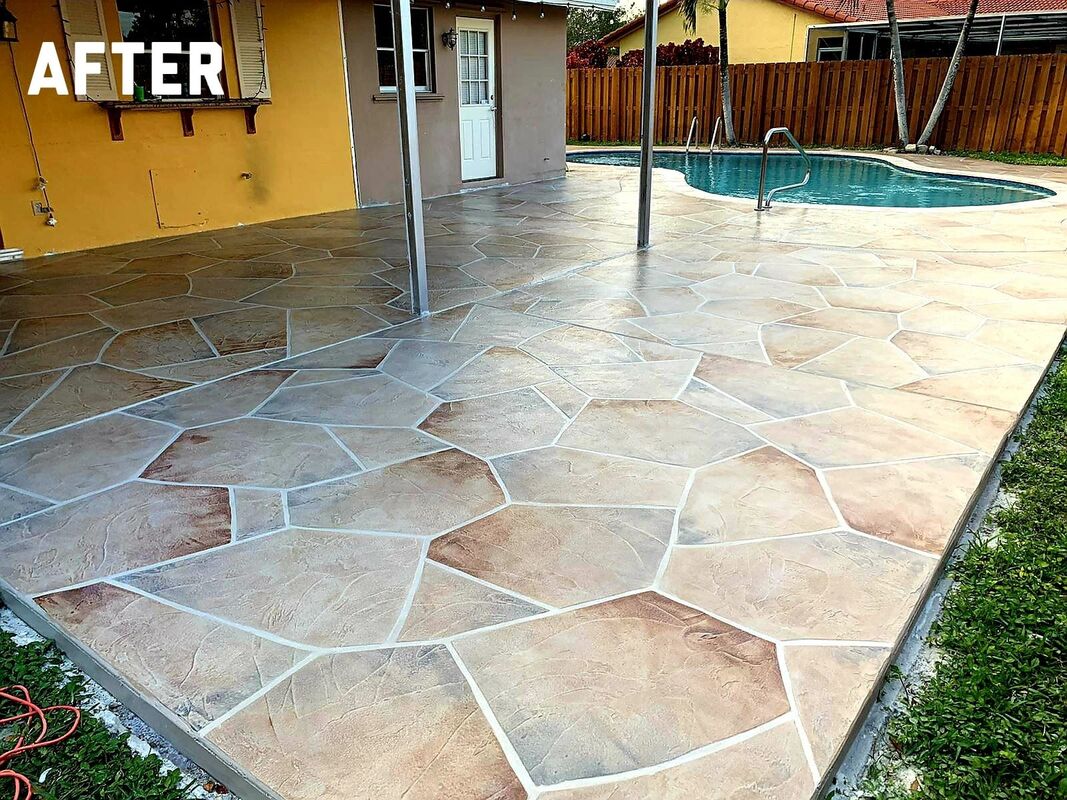 Picture of the back patio of a house finished with a stamped concrete patio in a decorative pattern of large gray stone with deep texture.